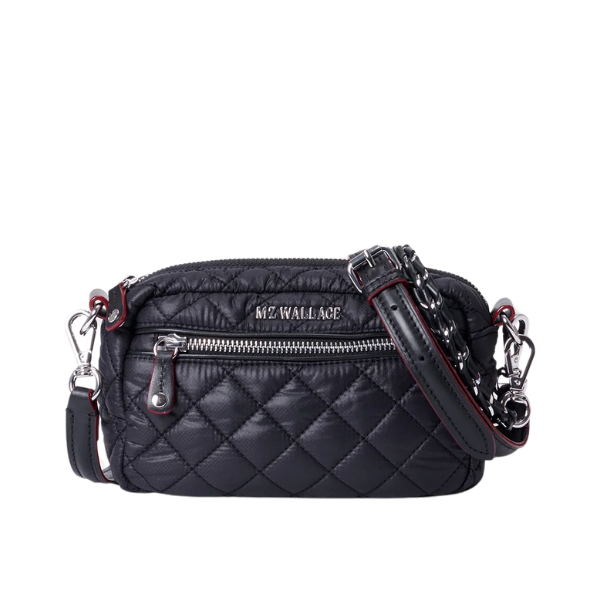 Black quilted handbag with silver zippers on a white background