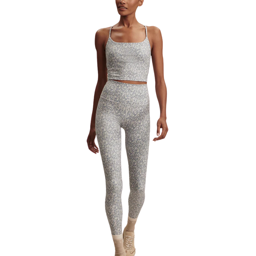 Woman wearing a Varley gray patterned athletic outfit on a white background