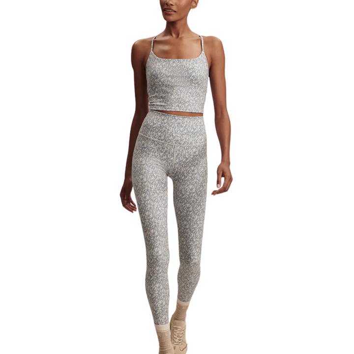 Woman wearing a Varley gray patterned athletic outfit on a white background